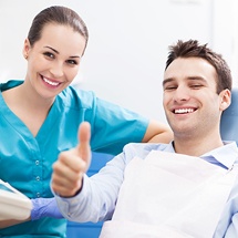 Young man in dental chair giving thumbs up