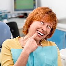 Older woman pointing to healthy smile