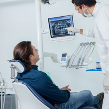 Dentist and patient looking at digital dental x-rays