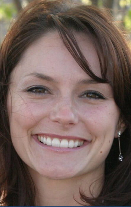 Woman with earrings smiling outside