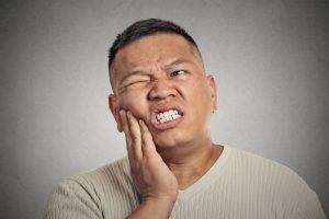 Pained man who needs to see his Joplin emergency dentist